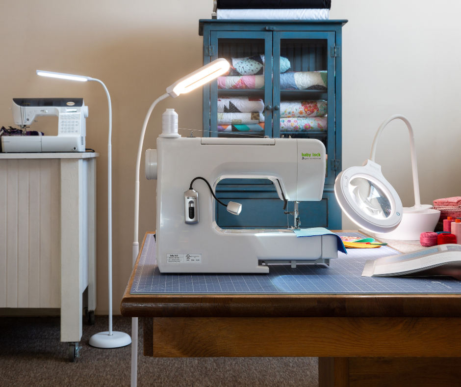 Clip-on sewing light and magnifier positioned over a quilt block at a sewing machine