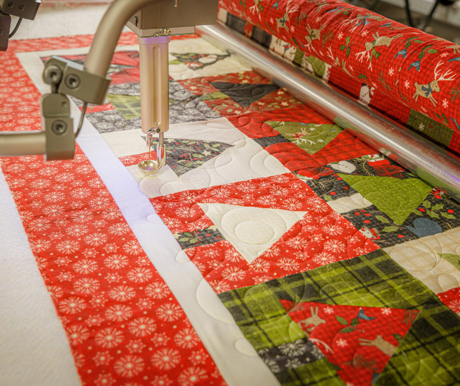 a festive red, white and green quilt on a longarm machine.