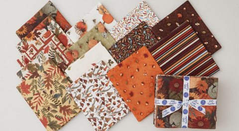 Fat quarter bundle of autumn prints in shades of brown, orange, gold, and ecru from the Autumn Homestead fabric collection.