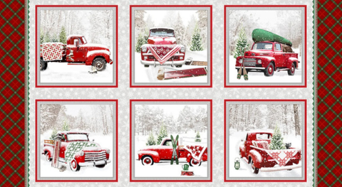 Panel of cotton quilt fabric featuring festive red trucks on a white and gray background.